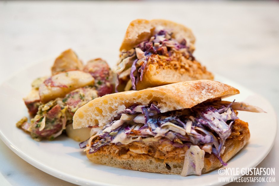 Blue cheese coleslaw tops a sandwich of pulled roasted chicken.
